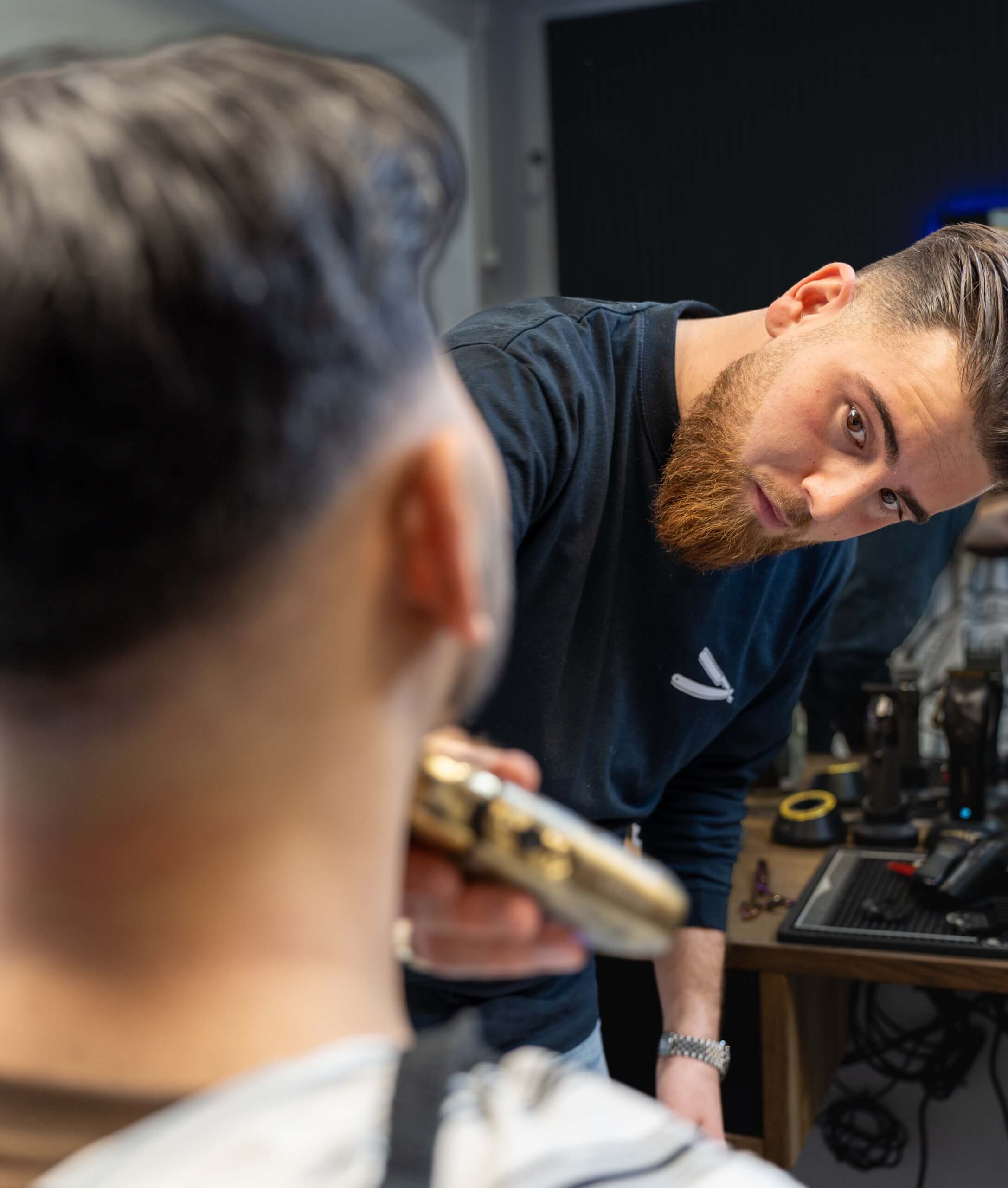 Frisør klipper kunde i moderne barbersalon, billede taget som en del af Unlimited Squares videoabonnement til virksomheder